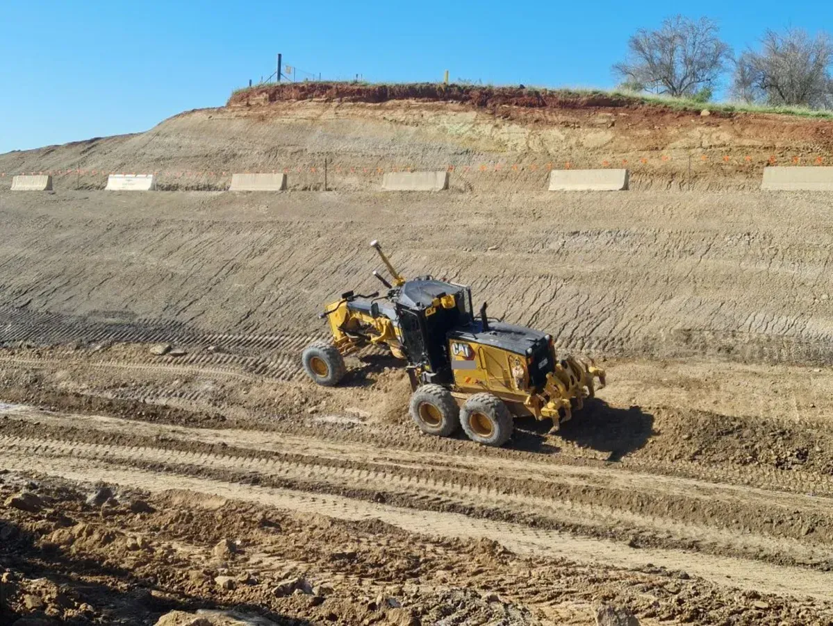 A grader shaping an embankment on a TAM Civil earthworks site