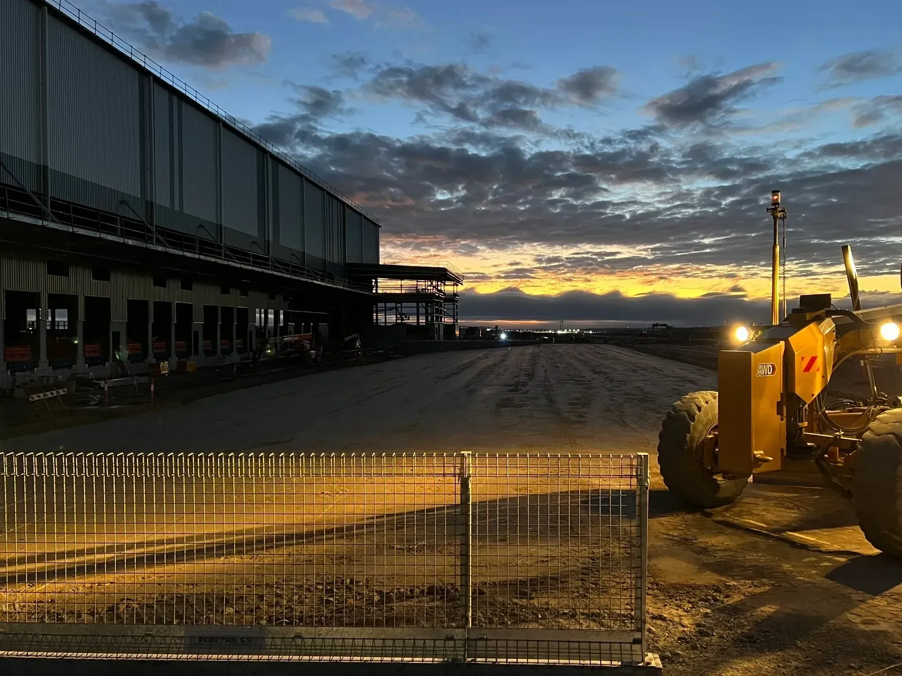 Earthworks site at dusk with heavy plant